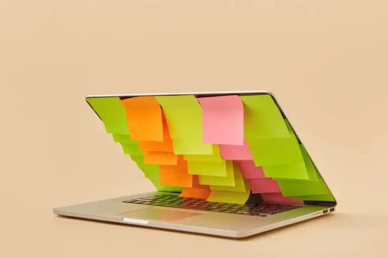 Laptop mit bunten Haftnotizen rund um den Bildschirm