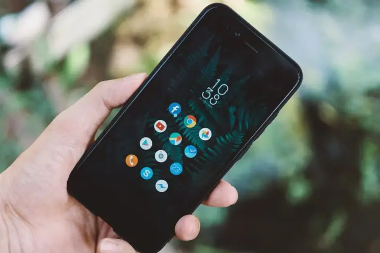Hand hält ein Smartphone mit App-Symbolen