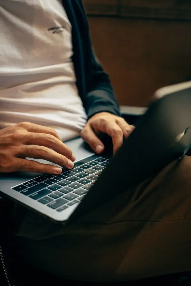 Person arbeitet am Laptop in dunkler Umgebung