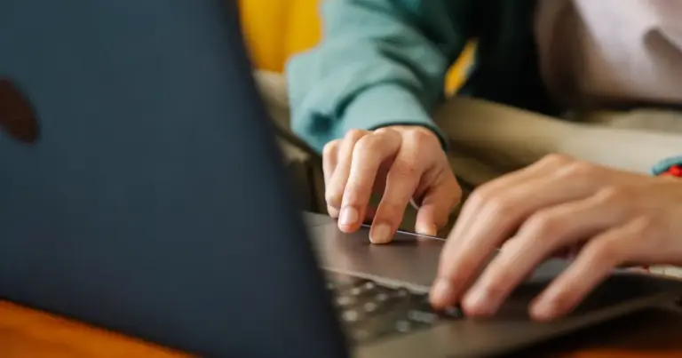 Hände am Laptop bei warmem Licht