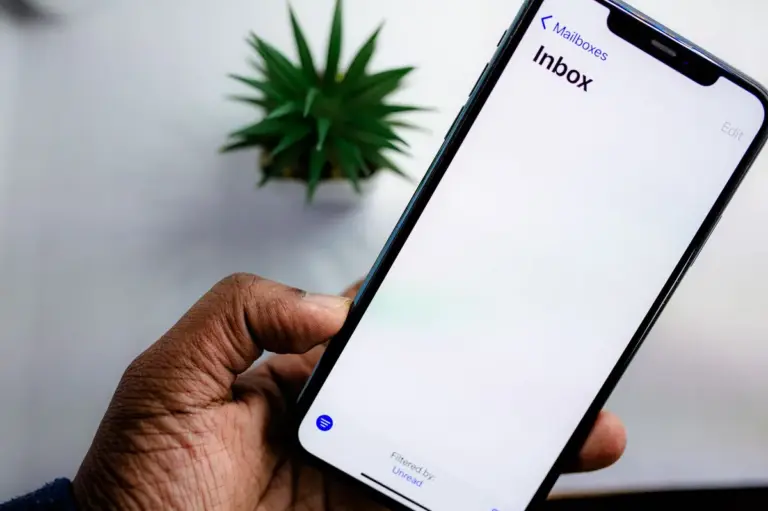 Hand hält ein Smartphone mit geöffnetem Postfach