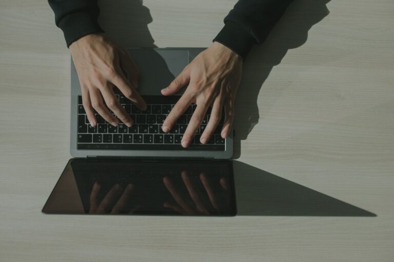 Haende tippen auf einer Laptop-Tastatur, um das Hotmail-Passwort zurueckzusetzen