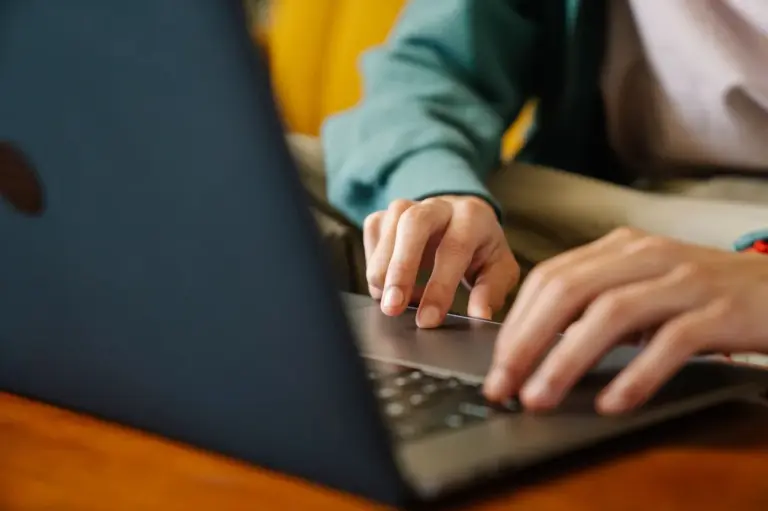 Hände tippen auf einer Laptop-Tastatur ein neues Passwort ein