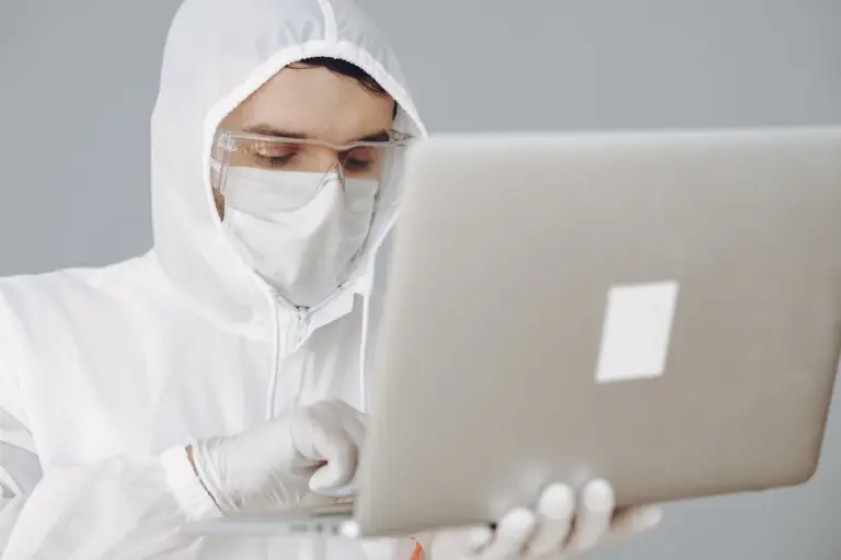 Person in Schutzkleidung am Laptop, Schutz vor Schadsoftware