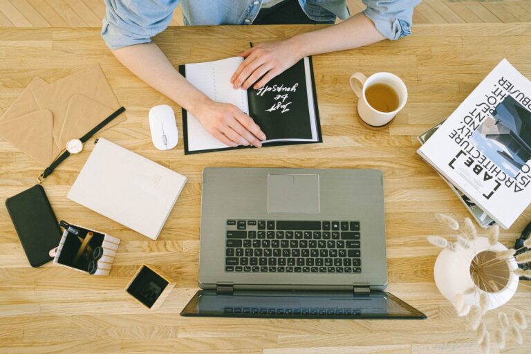 Aufgeraeumter Schreibtisch mit Laptop und Notizbuch als Sinnbild fuer geordnete Passwoerter