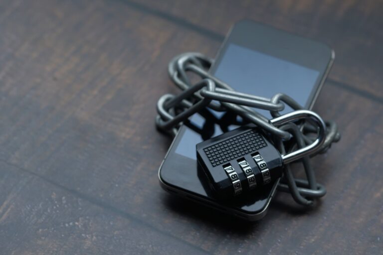 Smartphone mit Kette und Vorhaengeschloss als Sinnbild fuer ein abgesichertes Konto