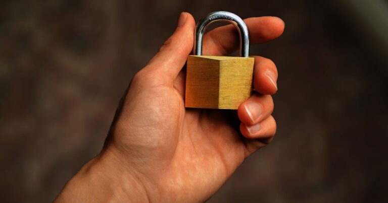 Hand haelt ein Vorhaengeschloss als Sinnbild fuer Passwortschutz und Kontosicherheit